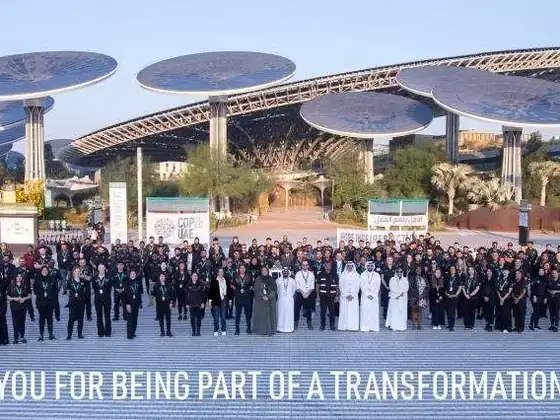 The COP28 UAE delivery team assembled at Expo City Dubai beneath the solar trees